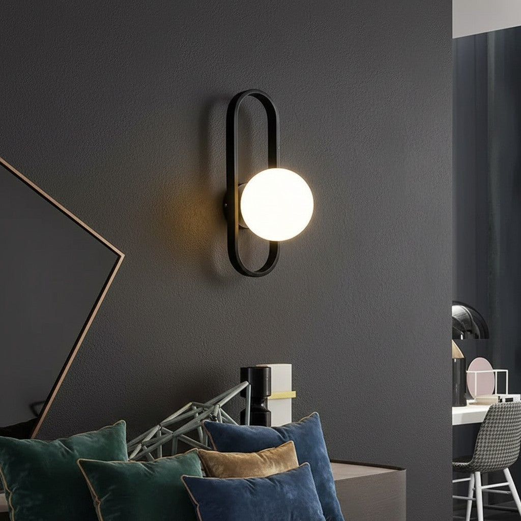 GoldenWatt luxury LED wall sconce with a frosted glass globe shade and black iron frame mounted on a dark wall