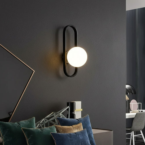 GoldenWatt luxury LED wall sconce with a frosted glass globe shade and black iron frame mounted on a dark wall
