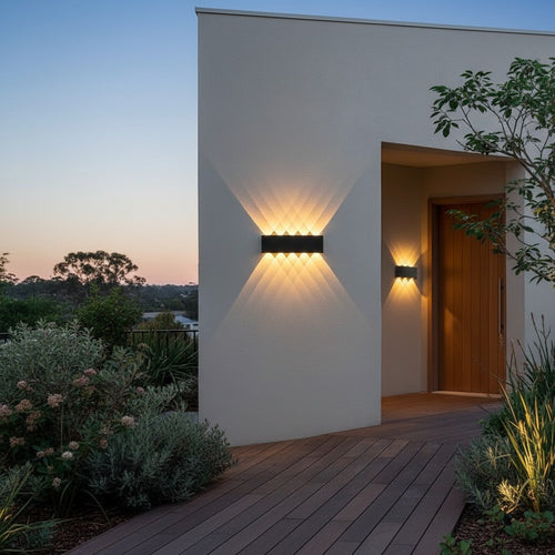 GoldenWatt black rectangular LED up and down wall sconce mounted on a modern home exterior porch at dusk