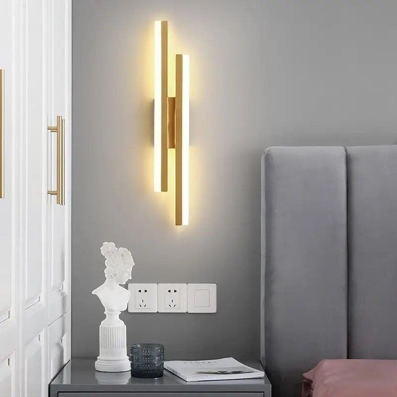 GoldenWatt dimmable gold LED wall sconce with modern iron and acrylic design mounted in a contemporary bedroom.