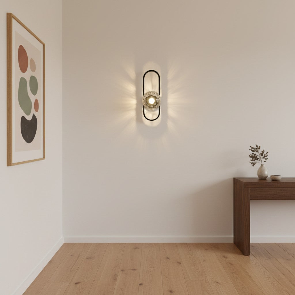 GoldenWatt luxury LED wall sconce with a frosted glass stone shade and black iron frame mounted on a minimalist wall