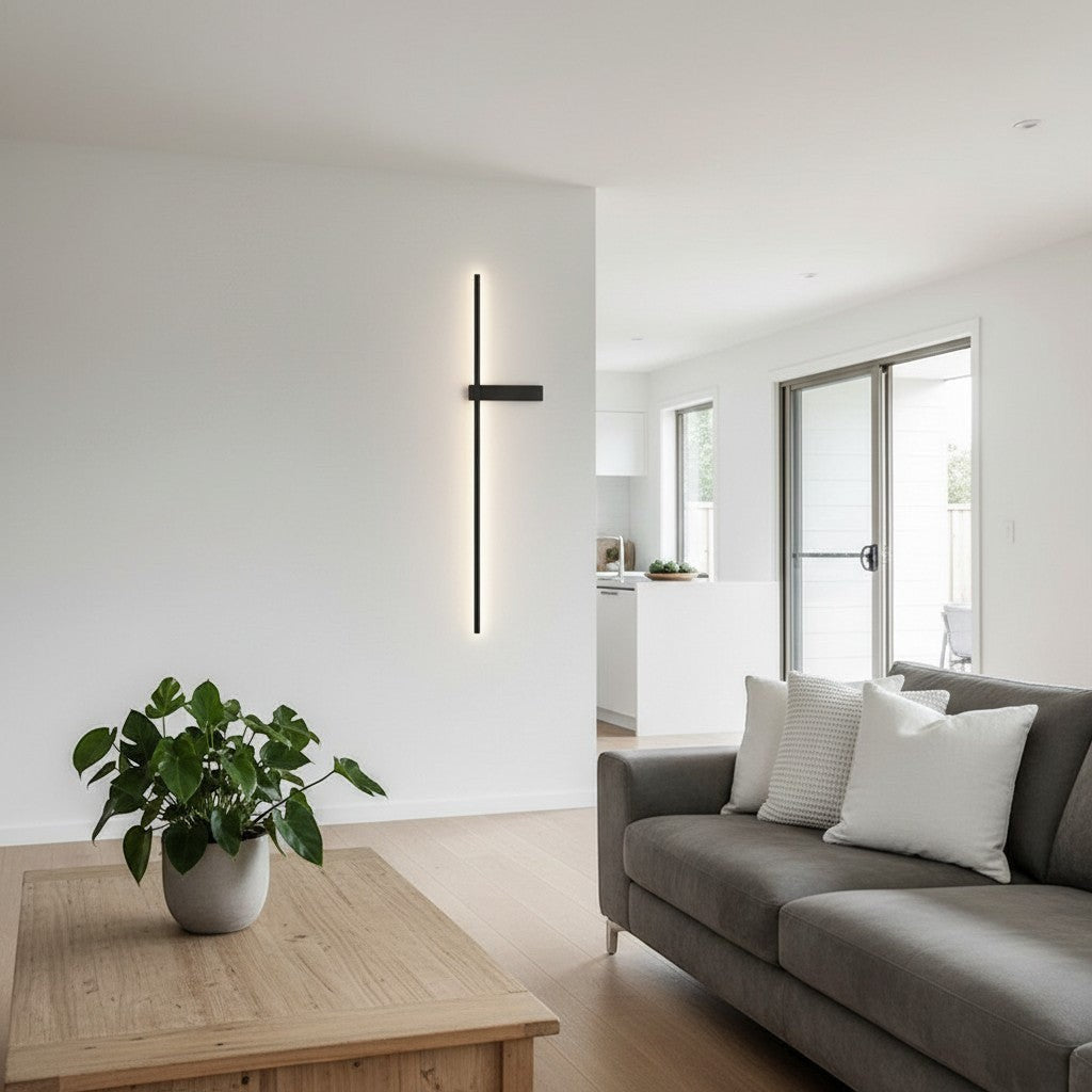 GoldenWatt modern minimalist dimmable LED strip wall sconce in black iron, mounted on a white living room feature wall.