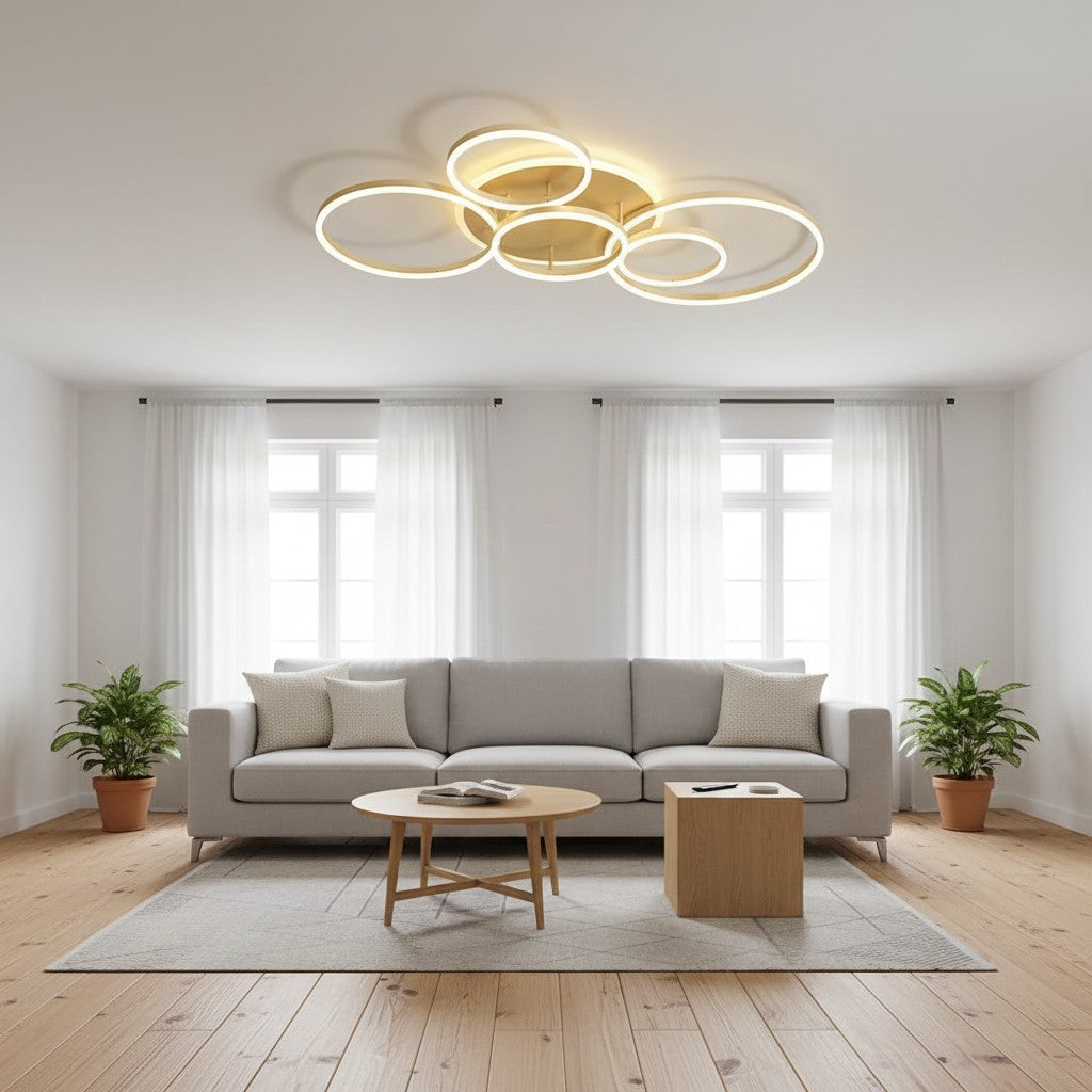 GoldenWatt modern gold LED ceiling chandelier with multiple rings in a bright, minimalist living room setting.