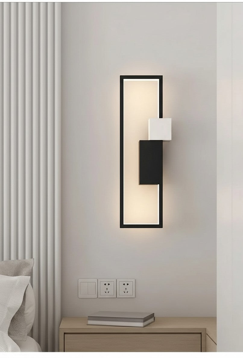 GoldenWatt modern rectangular LED wall lamp with black frame and white accent blocks mounted in a bedroom interior