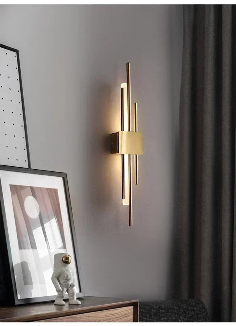 GoldenWatt Nordic contemporary LED wall sconce in gold finish with acrylic accents mounted on a grey bedroom wall