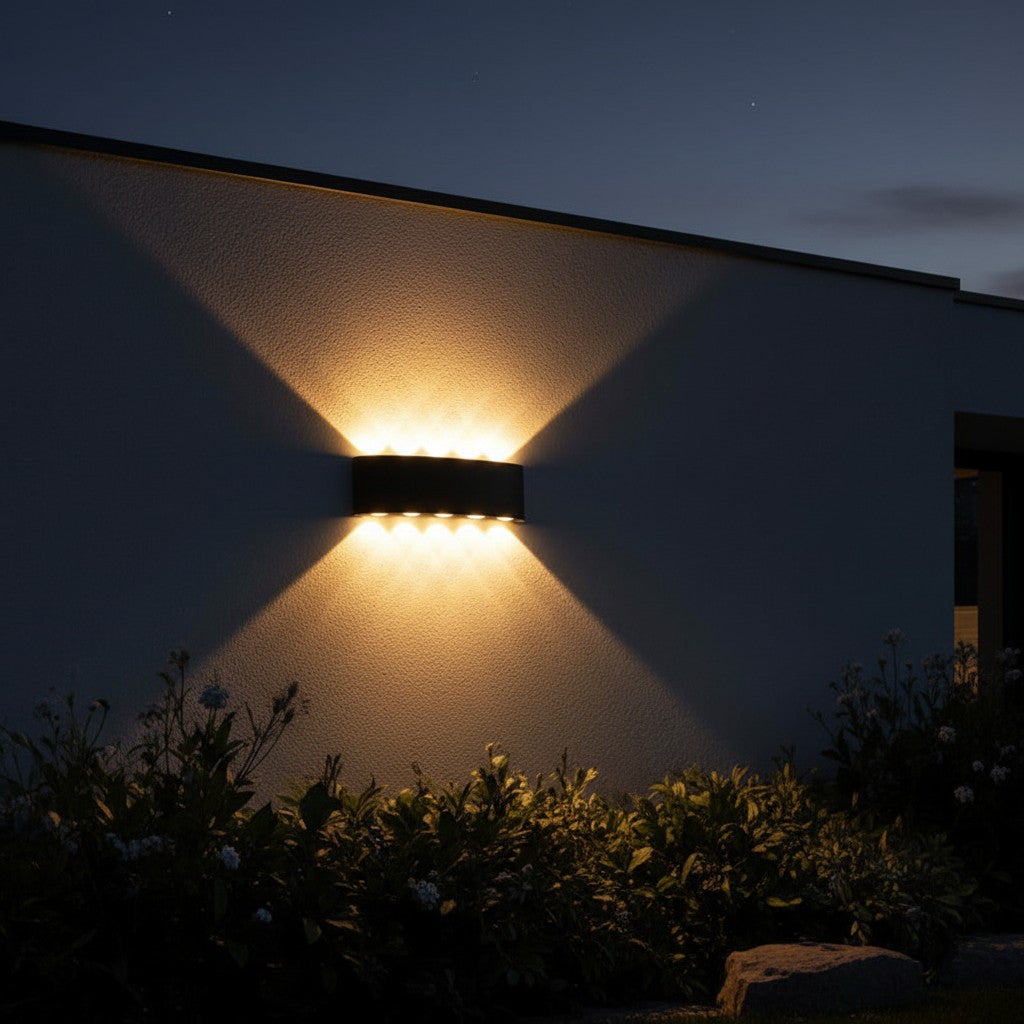 GoldenWatt outdoor LED wall sconce casting warm up and down light beams on a dark exterior wall at night